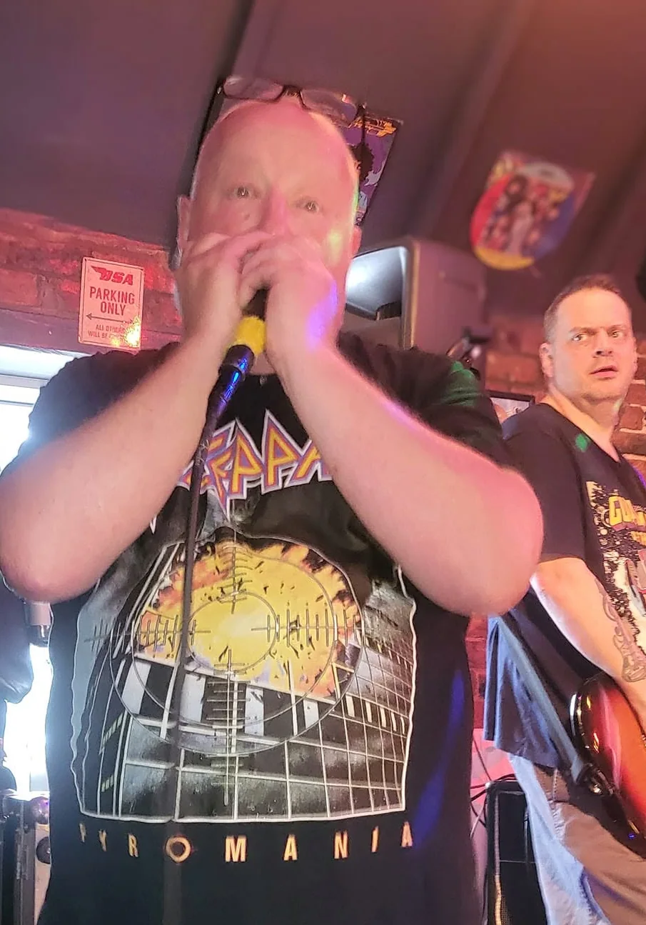 Derek Farley playing harmonica