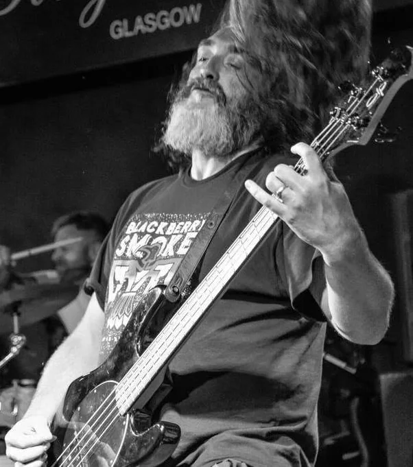 Paul Livett playing bass guitar